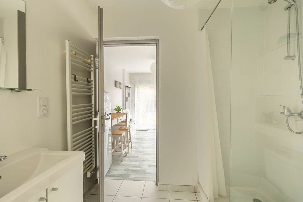 Salle d'eau avec douche, lavabo et sèche-serviettes